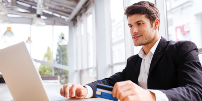 graphicstock-happy-young-businessman-using-laptop-and-credit-card-at-the-table Tax Implications of Bitcoin